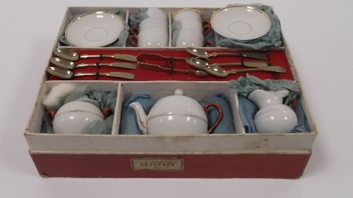 A late 19th Century dolls' tea service, in original box, complete with spoons and pair of tongs