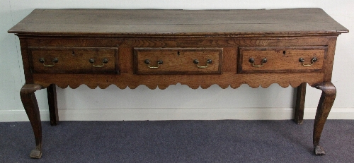 An 18th Century oak dresser, with three crossbanded drawers above a shaped apron, on square cabriole