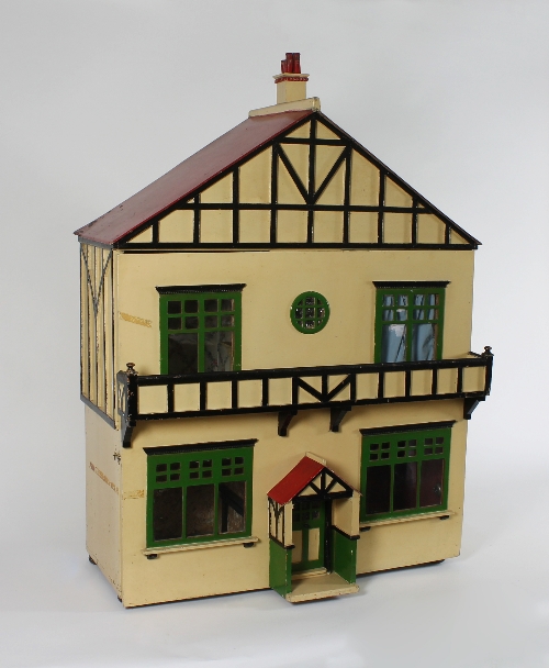 A wooden dolls' house of mock Tudor design, circa 1930, with four glazed windows, circular window
