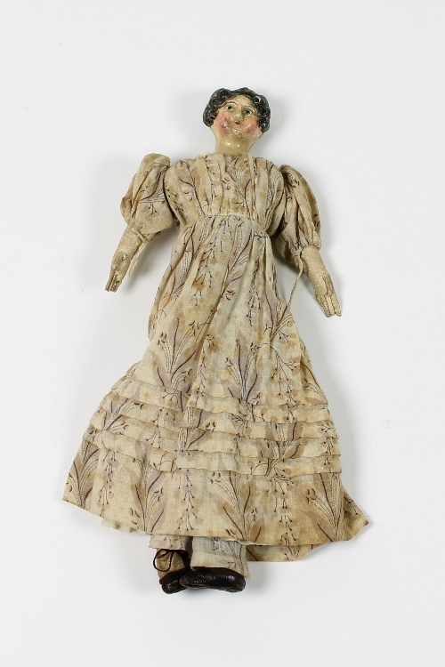 An early 19th Century papier-mache doll with hair in ringlets, blue eyes and rouged cheeks, the