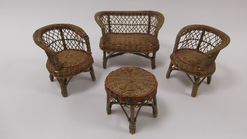 A wicker suite of furniture comprising a table, pair of tub shaped chairs and a tub shaped settee
