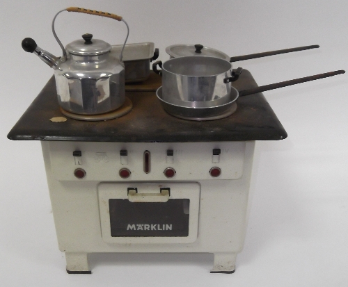 A child's Märklin white enamel electric cooker with three plates and an oven, and various