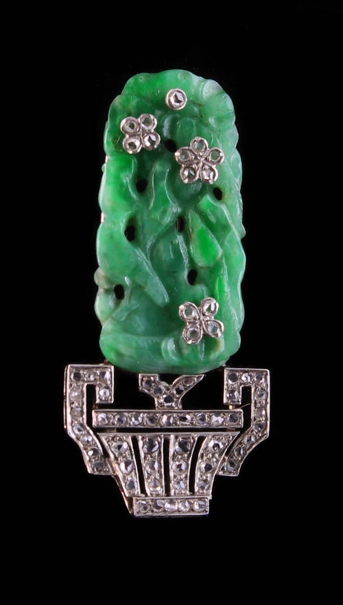 A Cartier style jade and diamond clip, the leaf carved jade plaque with diamond set flowerheads,