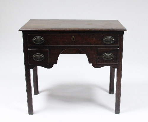 A late 18th Century oak kneehole desk, the top with rectangular moulded border, fitted a surround of