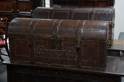 A pair of tooled leather and brass stud work dome topped chests, 107cm (42") wide