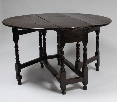 An oak oval two-flap gate-leg table on baluster turned legs and square stretchers, 109cm (43") wide