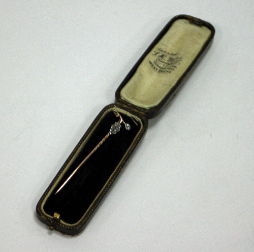 A diamond stick pin, the terminal modelled as a holly leaf and berry, cased