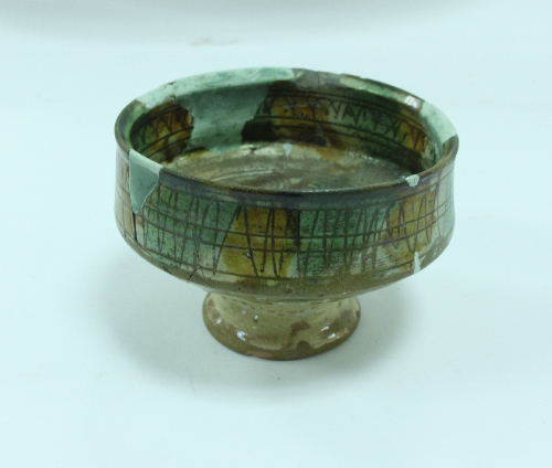 A Byzantine glazed pottery footed bowl, 5th - 6th Century AD, glazed in green and ochre on an