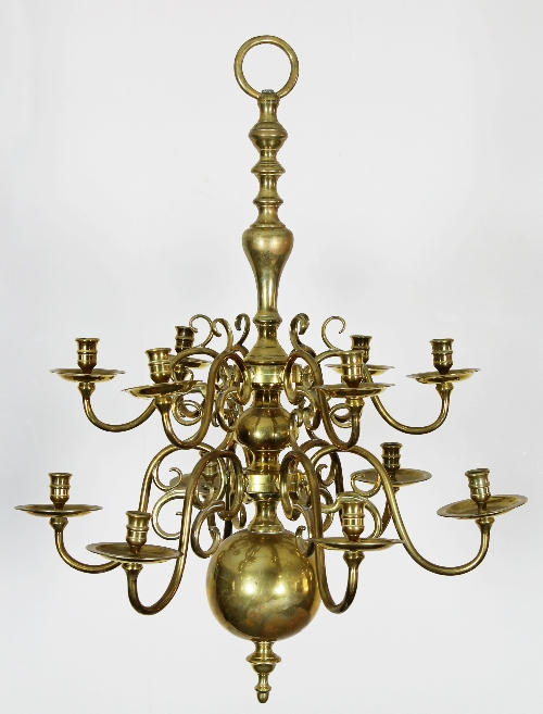 A Dutch 17th century style brass candelabra, with two tiers of six candle arms on a baluster stem,