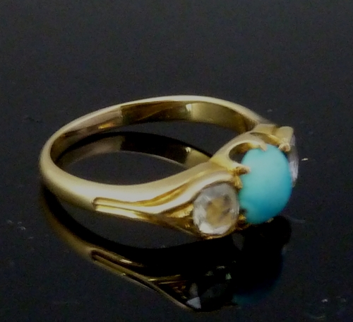 A turquoise and diamond three-stone ring, the central turquoise bead flanked by two diamonds to