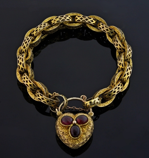 A Victorian gold bracelet of pierced oval links to a heart shaped padlock clasp centred by a trefoil