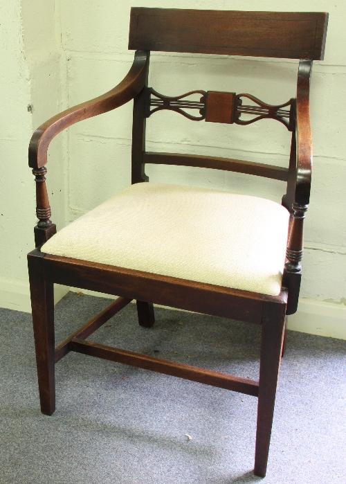A 19th Century mahogany open armchair with trap seat on tapering legs