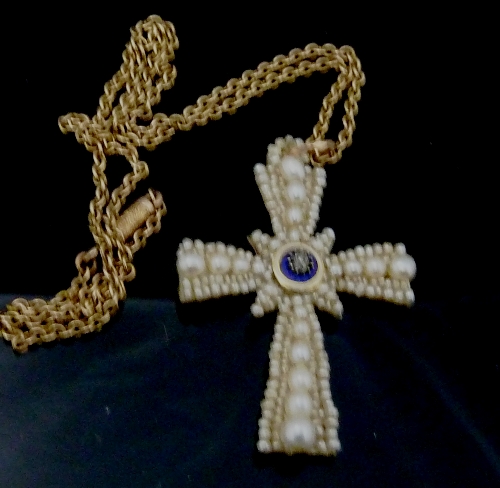 A pearl set cross centred by a small diamond on a blue and white enamel disc, all mounted on a