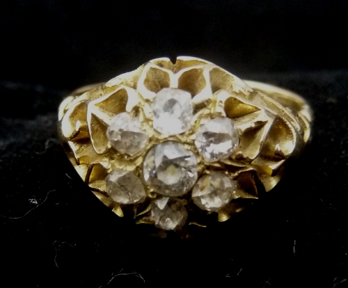 A diamond cluster ring, claw set in a pierced setting with scroll shoulders, ring size Q½