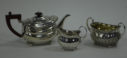 A matched George III three-piece tea service, each piece with gadrooned borders on four ball feet,