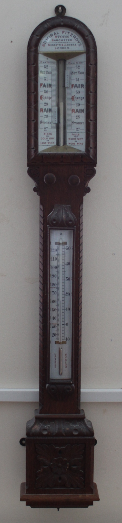 A 19th Century Admiral Fitzroy's stick barometer in a carved oak case with white enamel dials,