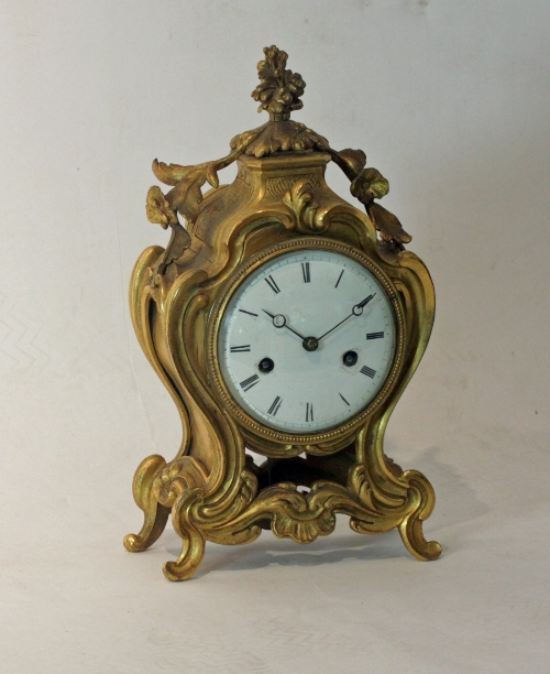 A 19th Century French ormolu mantel clock, the case with vase of flowers finial and scroll