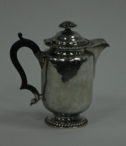 A silver hot water jug, William Hutton & Sons Ltd, London 1899, with leaf moulded finial, ebonised