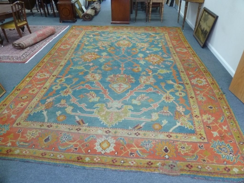 A large Oushak West Anatolia carpet, circa 1910, with pole medallions on a blue ground with an
