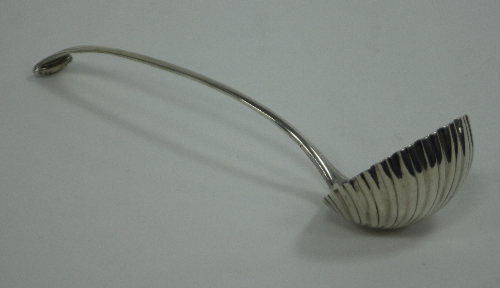 An 18th Century English silver ladle, marks obscured, with scroll terminal and shell bowl