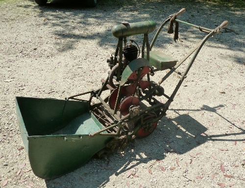 A vintage cast iron frame Atco lawn mower with torpedo fuel tank and tool box, complete with grass