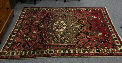 A rug with central medallion on a red ground, 190cm (75") long