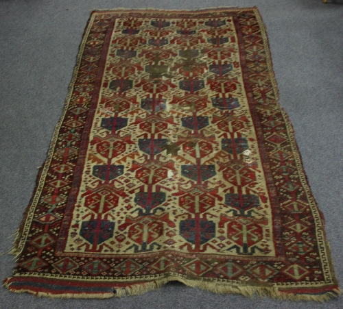 A rug with shield shaped medallions on a white ground within a guard stripe, 230cm x 120cm (90.5"