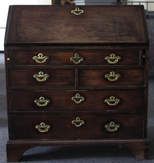 An 18th Century mahogany bureau, fitted drawers, pigeon holes and central cupboard beneath the fall,