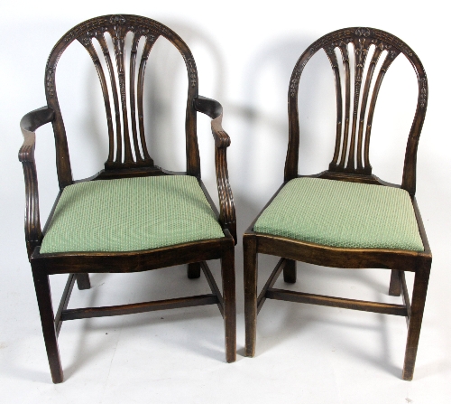 A set of twelve George III style mahogany dining chairs with husk carved hoop backs and carved