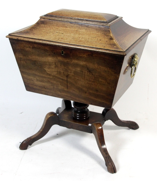 A Regency mahogany cellaret, circa 1810, the sarcophagus box with lion mask ring handles on four