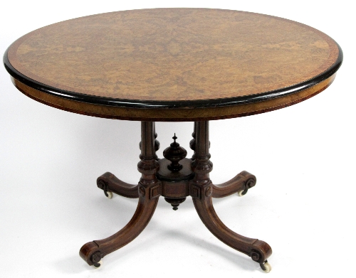 A late Victorian figured walnut oval table, with boxwood stringing and ebonised border on