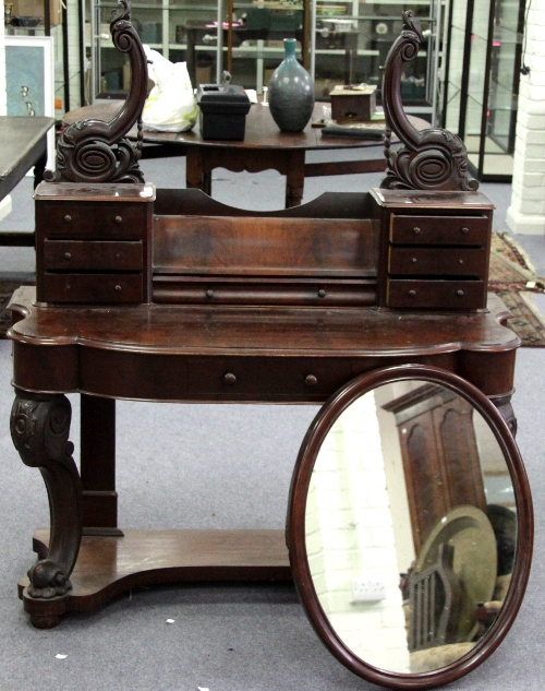 A Victorian mahogany dressing table on carved cabriole legs with oval mirror over, 127cm (50")