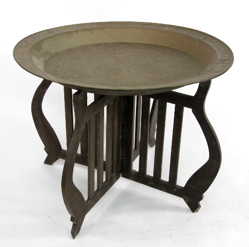A large brass table top, decorated an elephant by a lake, 92cm (36") wide, with wooden stand
