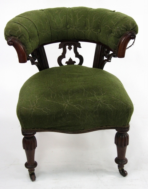 A Victorian walnut tub-shaped armchair with scroll terminations to the cresting, pierced upright