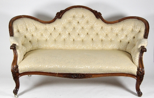 A Victorian walnut settee with carved and moulded frame on cabriole legs, button upholstered,