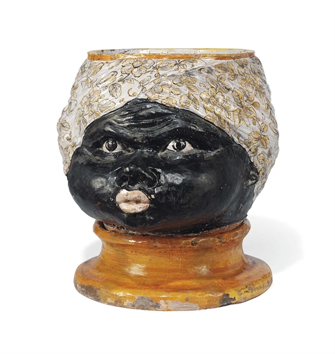 A LARGE ITALIAN GLAZED BLACKAMOOR TERRACOTTA JARDINIERE 
CIRCA 1920 
In the form of a blackamoor