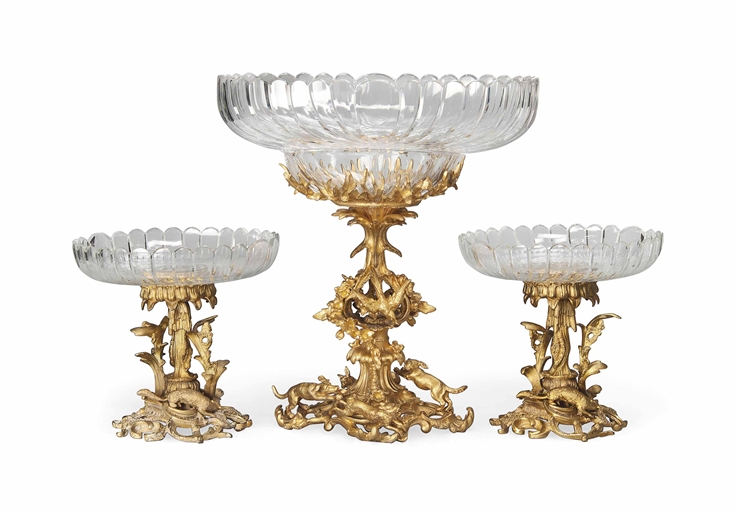 A VICTORIAN GILT-BRONZE AND GLASS THREE-PIECE TABLE GARNITURE 
CIRCA 1860 
Comprising a pair of
