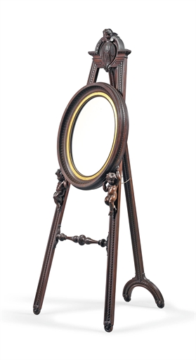 AN UNUSUAL CARVED WALNUT EASEL MIRROR 
LATE 19TH  EARLY 20TH CENTURY 
The oval mirror supported by