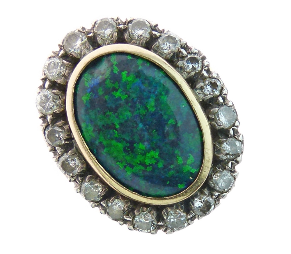 Black opal and diamond cluster ring, the oval shallow cabochon 15.5mm long, enclosed by eighteen