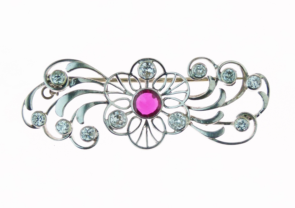 Diamond and ruby brooch, the central round cut ruby within a hexafoil openwork mount with three