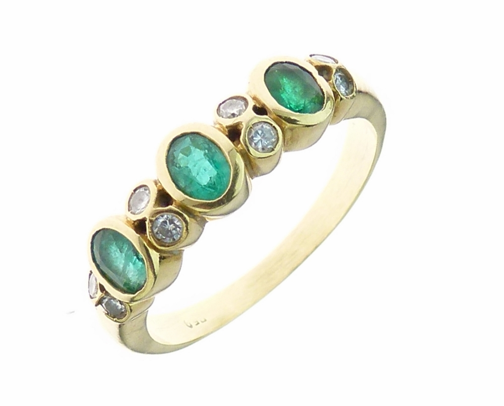 Emerald and diamond dress ring, the three oval cut stones with pairs of brilliant cut diamonds