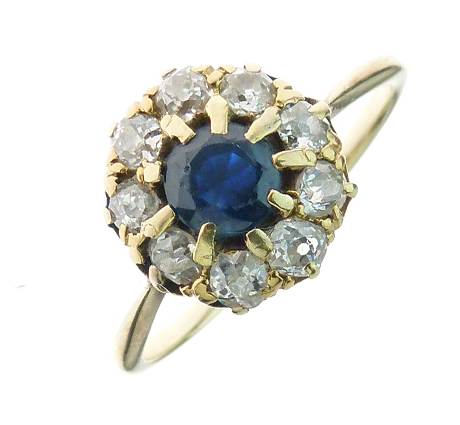 Sapphire and diamond cluster ring, the round cut stone enclosed by nine old brilliant cuts totalling