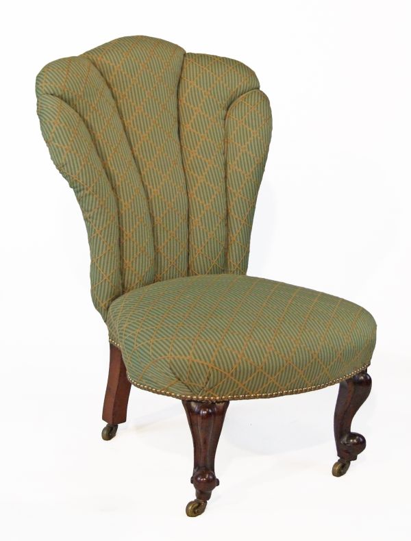 Victorian nursing chair upholstered in brass studded gold and green fabric and standing on