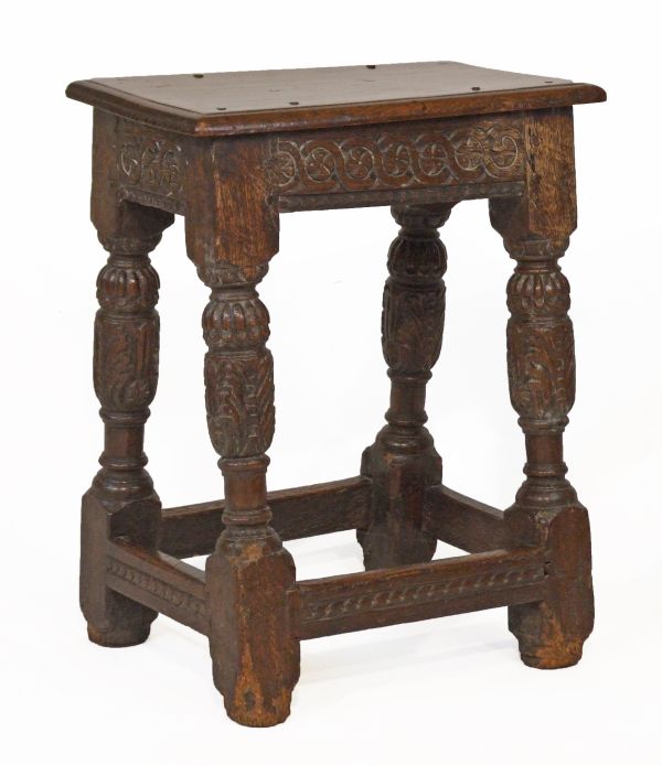 18th Century oak joined stool having a carved continuous frieze and standing on carved baluster