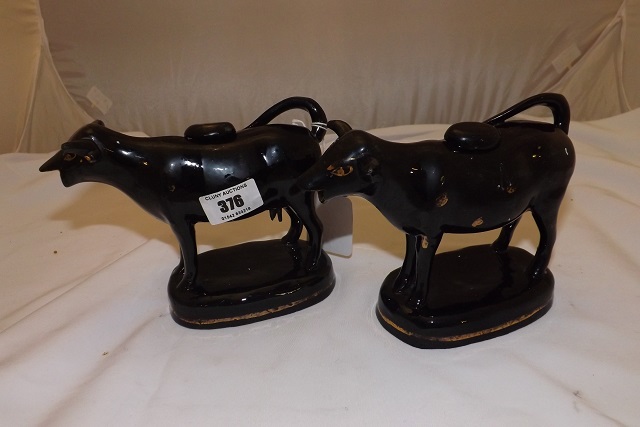 TWO VICTORIAN BLACK WITH GILDING COW CREAMERS STANDING APPROX 5" HIGH