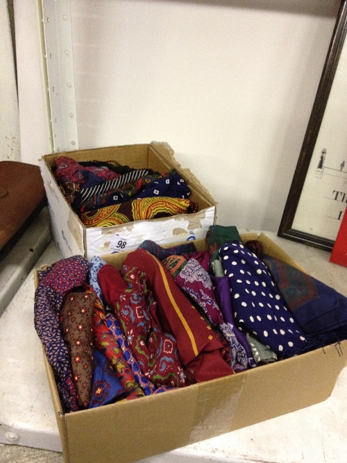 Two boxes containing various gentleman's silk cravats and scarves.