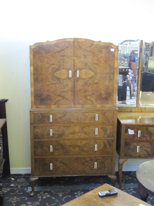 An Art Deco figured walnut compactum with cupboard and four drawers under.