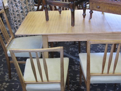 A Gordon Russell extending teak dining table together with six matching dining chairs, possibly made