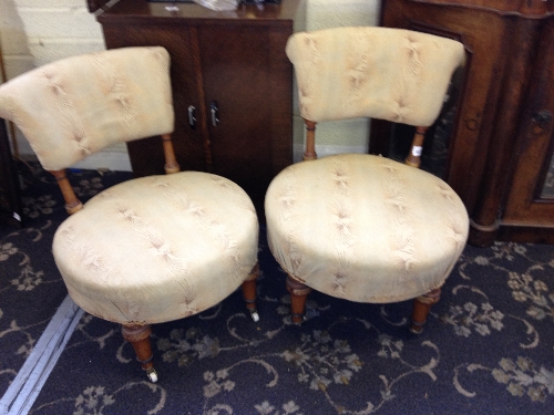 A pair of walnut framed low upholstered chairs resting on turned front supports.