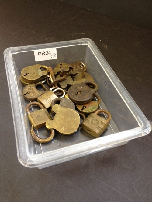 A carton containing various small brass and iron padlocks.